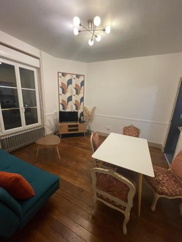 un salon avec une table et des chaises blanches dans l'établissement Maison Jean-Pierre, à Magenta