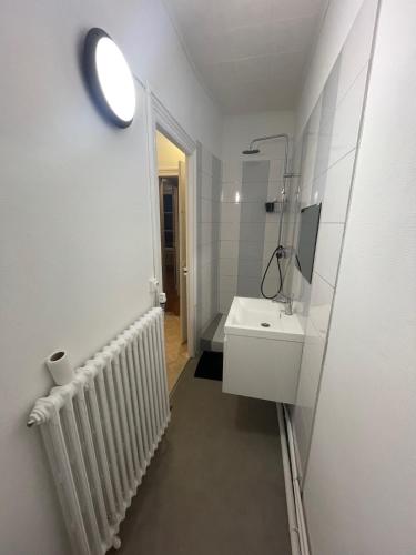 une salle de bain blanche avec un lavabo et un miroir dans l'établissement Maison Jean-Pierre, à Magenta