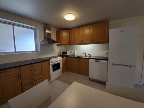 a kitchen with wooden cabinets and a white refrigerator at Beautiful Central Apartmant in Strand