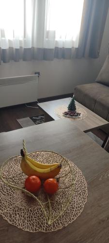 a banana and two tomatoes on a plate on a table at Apartman LuPa in Kopaonik