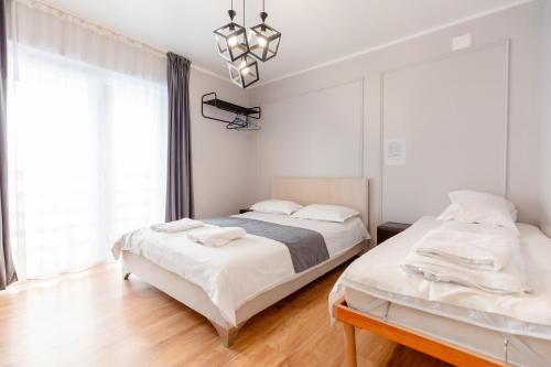 a bedroom with two beds and a chandelier at Complex turistic Veverita in Ranca