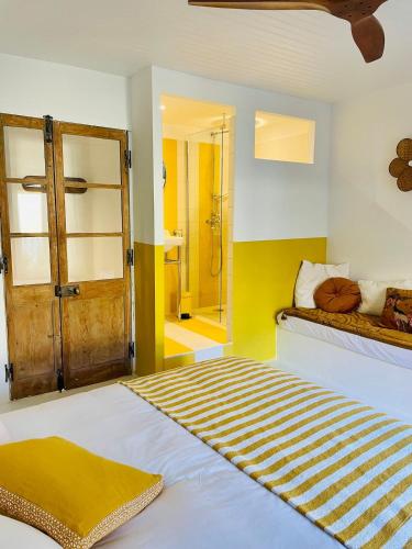 une chambre avec un lit et une salle de bain avec douche dans l'établissement Made moiselle Uzès - Superbe et lumineux appartement centre historique 2 chambres, à Uzès