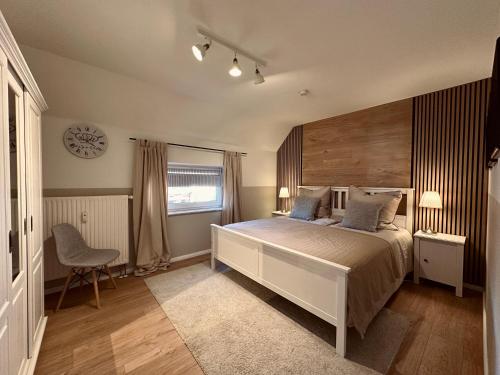 a bedroom with a bed and a clock on the wall at VILLARE8 OG APARTMENT - Moderne Wohnung im Landkreis Gifhorn in Adenbüttel