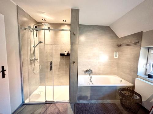 a bathroom with a shower and a bath tub at VILLARE8 OG APARTMENT - Moderne Wohnung im Landkreis Gifhorn in Adenbüttel