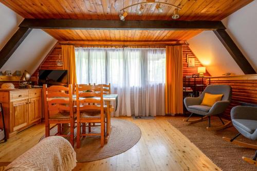 a kitchen and dining room with a table and chairs at Tiltott Rengeteg Vendégház in Balatonfůzfő