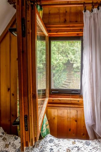 a bedroom with a bed and a window in a house at Tiltott Rengeteg Vendégház in Balatonfůzfő