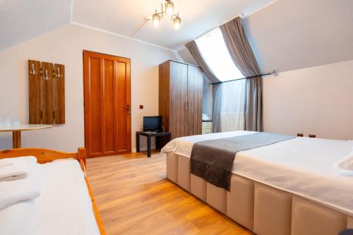 a hotel room with two beds and a television at Complex turistic Veverita in Ranca