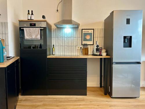 a kitchen with a refrigerator and a counter top at Karl Central Flats - Netflix - Parkplatz - Balkon in Trier