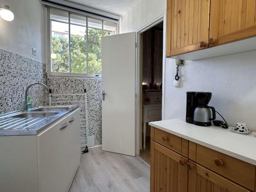 une petite cuisine avec un évier et une fenêtre dans l'établissement Appartement 2 pièces en duplex BANYULS SUR MER BN100-C232, à Banyuls-sur-Mer