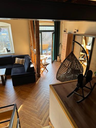 a living room with a couch and a chair at Dawna Mleczarnia Apartamenty LOFT in Nowa Ruda