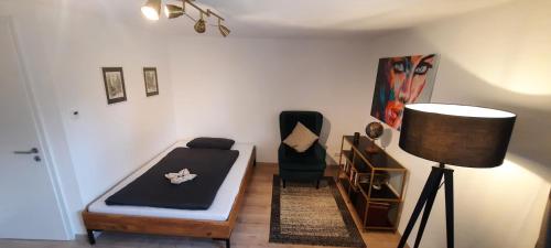 a room with a bed and a chair and a lamp at Ferienwohnung Am Illerradweg in Waltenhofen