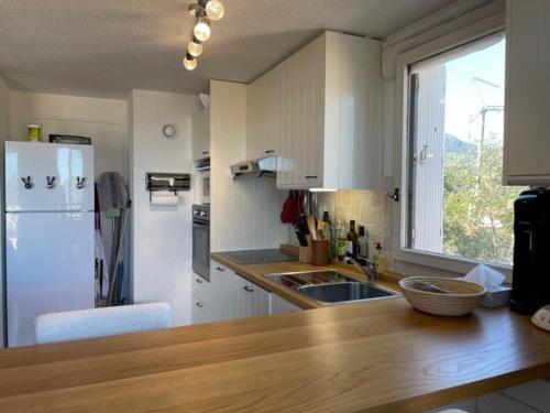 Il comprend une cuisine équipée d'un comptoir et d'un réfrigérateur blanc. dans l'établissement Appartement T3 Mezzaine BANYULS SUR MER BN050-H07, à Banyuls-sur-Mer