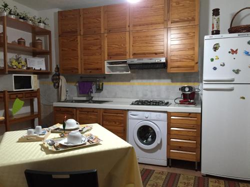 a kitchen with a table and a white refrigerator at B&B Magna Grecia in Crotone