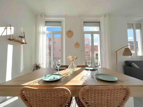 - une table à manger avec deux assiettes vertes dans l'établissement Appartement lumineux proche gare, à Hyères