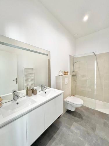 une salle de bain blanche avec des toilettes et un lavabo dans l'établissement Appartement lumineux proche gare, à Hyères