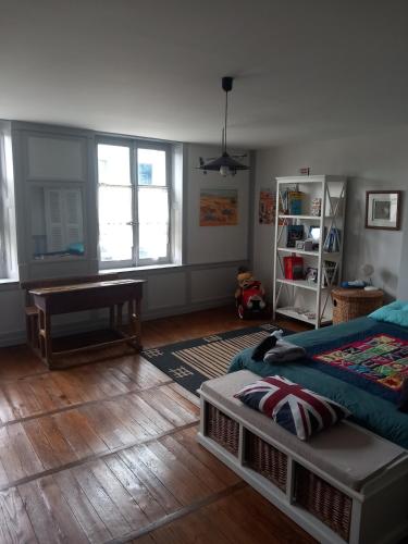 une chambre avec un lit et un parquet dans l'établissement Les Volets Bleus, à Gondrecourt-le-Château