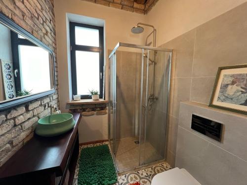 a bathroom with a shower with a green sink at Kaimukas - lake house for 15 persons 5 bedrooms in Dvarčėnai