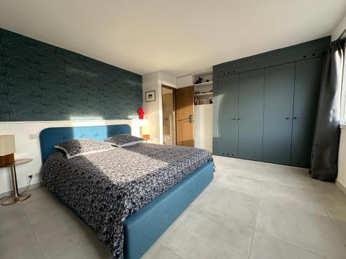 - une chambre avec un lit bleu et un mur dans l'établissement Laureto beach & E1027-Le Corbusier, à Roquebrune-Cap-Martin