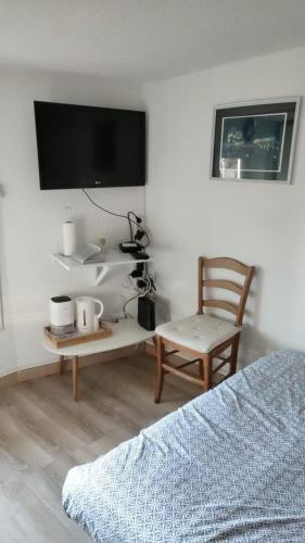 ein Schlafzimmer mit einem Bett, einem Schreibtisch und einem Stuhl in der Unterkunft Le Nid, petit studio cosy et central in Besançon