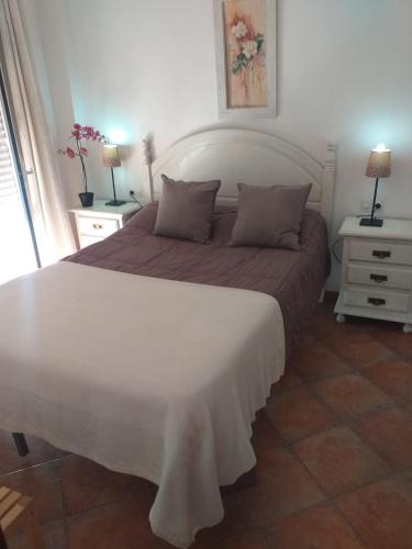 a bedroom with a large bed and two night stands at centro Puerto de Santamaria in El Puerto de Santa María