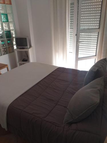 a bedroom with a large bed with a window at centro Puerto de Santamaria in El Puerto de Santa María