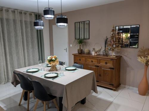 a dining room with a white table and chairs at Ideal 24h Le Mans and horse European pole in Savigné-lʼÉvêque