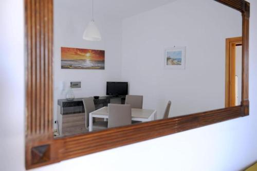 a mirror reflecting a living room with a table and chairs at Le Residenze Salentine - Case Vacanza in Lecce in Lecce