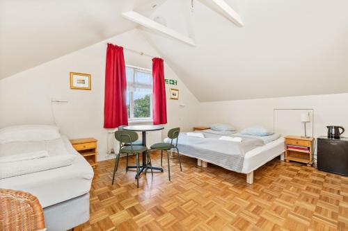 a room with two beds and a table at Downtown Reykjavík Baldursbrá Guesthouse in Reykjavík