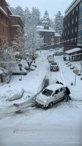 カミリアテッロ・シラーノにあるMarsila house Oneの雪に覆われた道路に駐車された車とそれを眺める人