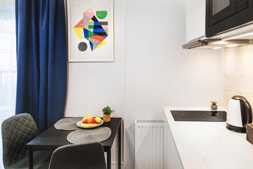 a kitchen with a table with a bowl of fruit on it at Stylowe Apartamenty w Centrum in Wrocław