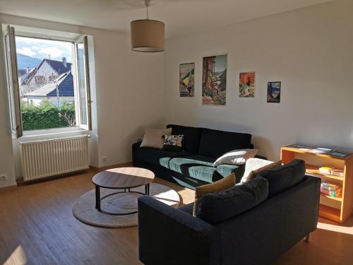 un salon avec un canapé et une table dans l'établissement Le Cocon Vert des Vosges, à Munster