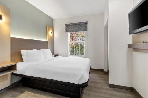 a bedroom with a white bed and a window at MainStay Suites Columbia Harbison in Columbia