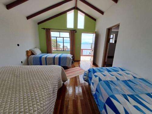 a room with two beds in a room with a window at Palacio del Inca Lodge in Comunidad Yumani