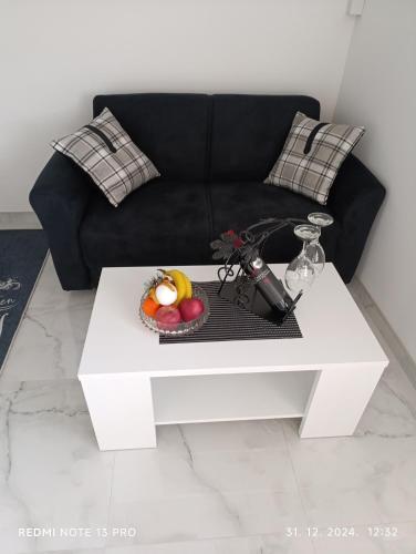sala de estar con sofá negro y mesa de centro blanca en Garfield Family Apartman 2, en Soko Banja