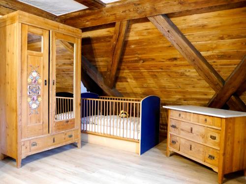 a room with a crib and a wooden ceiling at Der Grandlhof - Ferien am Hof in Krummennaab