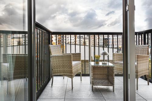 a balcony with wicker chairs and a table at Stylowe Apartamenty w Centrum in Wrocław