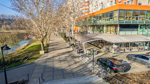 a street with cars parked in front of a building at Green Park & Lakeview Apartment in Chişinău