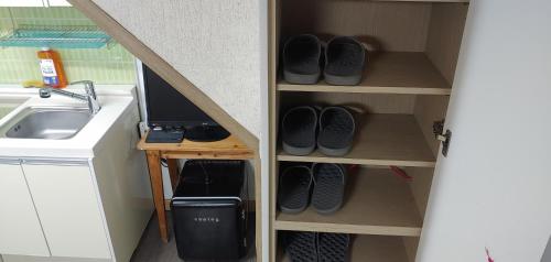 a closet with shoes and a sink in a room at Stayin Myeongdong Guesthouse - Foreigners only in Seoul