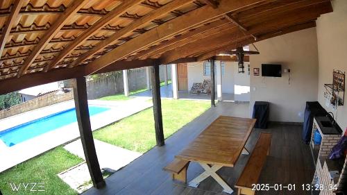 a patio with a table and a swimming pool at Chácara Por do Sol - Mairinque in Mairinque