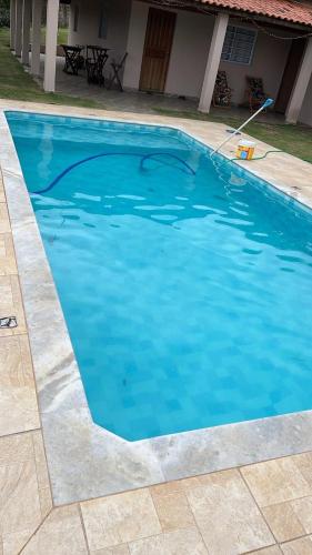 a large blue swimming pool in front of a house at Chácara Por do Sol - Mairinque in Mairinque