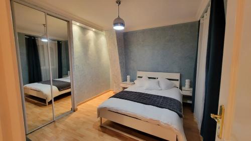une chambre avec un grand lit et un miroir dans l'établissement Maison spacieuse à Chelles, à Chelles