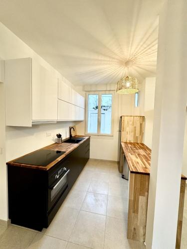 une cuisine avec des armoires blanches et un comptoir noir dans l'établissement Charmant Appartement - Stationnement gratuit, à Nantes