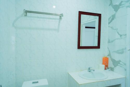 a white bathroom with a sink and a mirror at Vientiane Ruby Riverside Hotel in Vientiane