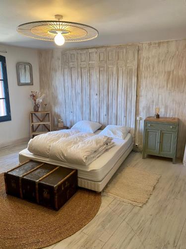 - une chambre avec un grand lit et un lustre dans l'établissement Maison de caractère à Saint-Nectaire le haut, à Saint-Nectaire