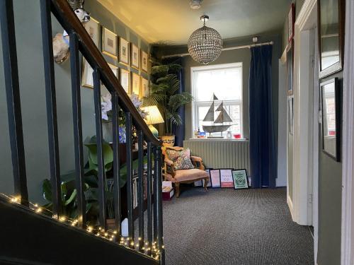 a hallway with a staircase with lights and a chair at One Drake Road, Tavistock, Devon in Tavistock