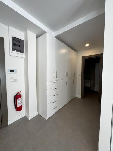 a room with white cabinets and a fire extinguisher at Su Apartment Side in Side
