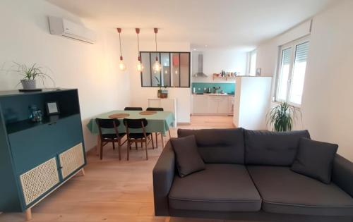 un salon avec un canapé et une table dans l'établissement Superbe appartement rénové à 250m des remparts, à Avignon