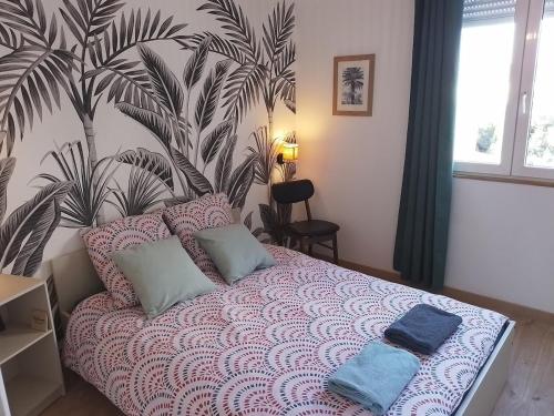 une chambre avec un lit avec une fresque végétale sur le mur dans l'établissement Superbe appartement rénové à 250m des remparts, à Avignon