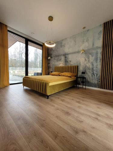 a large bedroom with a bed and a large window at Ostatni dom po lewej in Białe Błoto