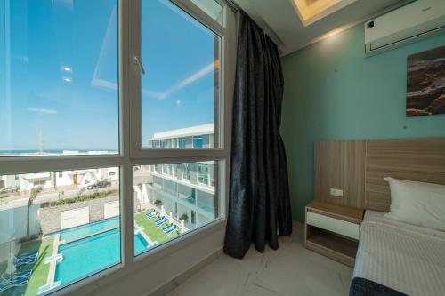 a bedroom with a large window and a swimming pool at Sky Star Hotel free shuttle to Hurghada City center in Hurghada